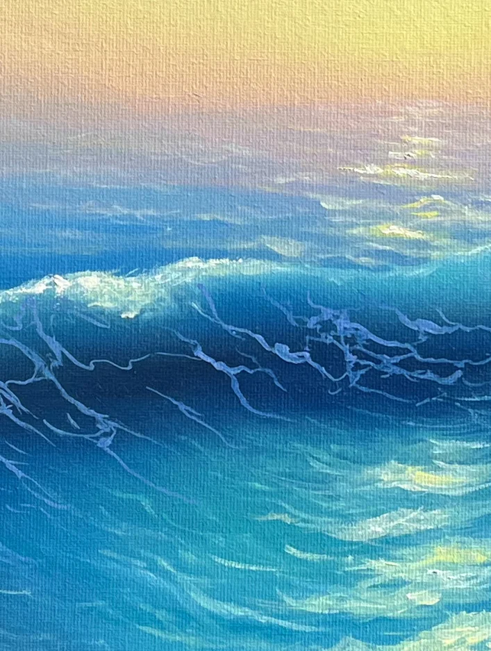Close detail: the crest of a turquoise wave, the low sun scattered in pale flecks across the water above it