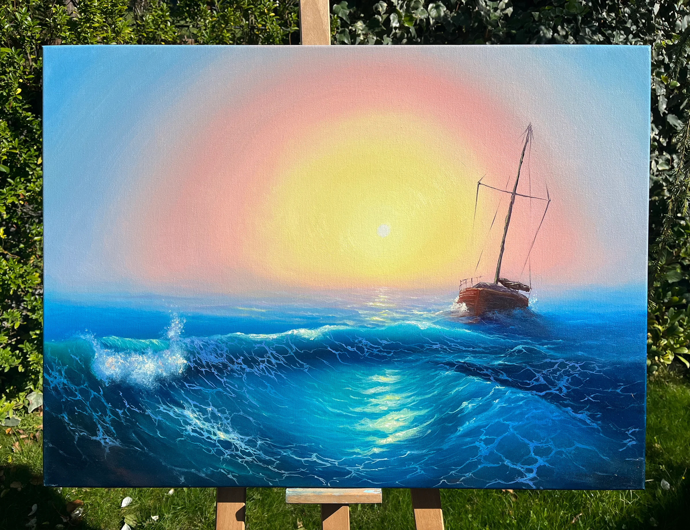The finished canvas on a wooden easel in a garden, daylight on the paint and greenery behind